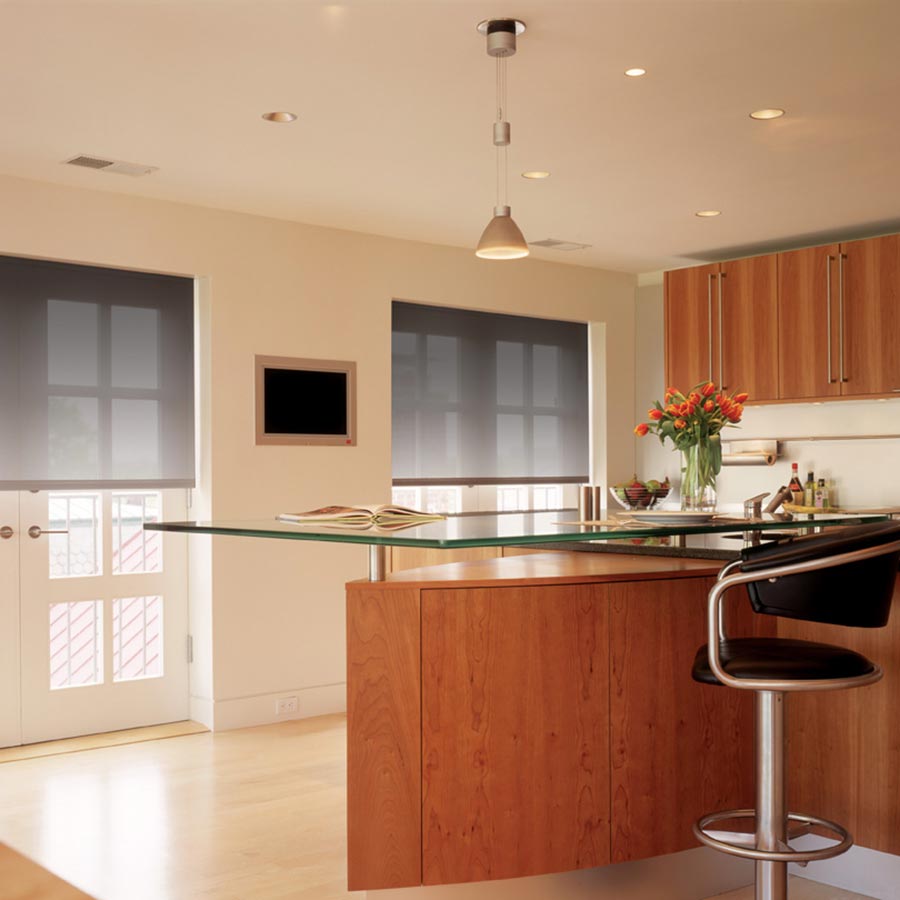 Modern kitchen with glass-topped island, pendant lighting, and wooden cabinetry, creating a sleek look.