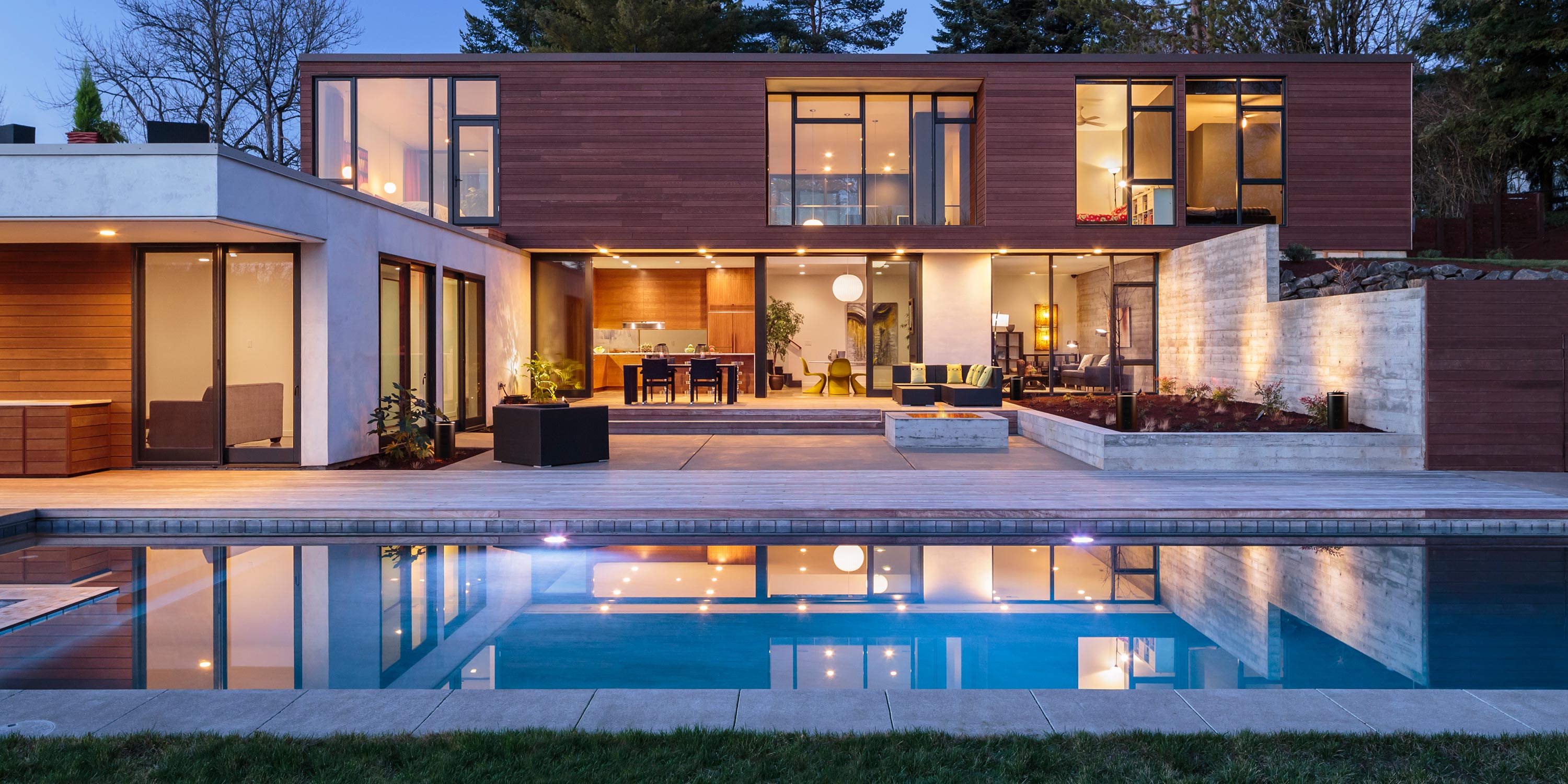 Modern home exterior with a pool, large windows, and sleek landscaping.