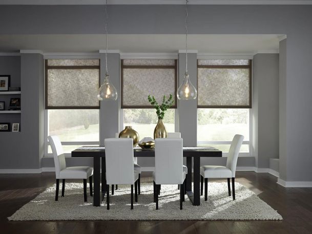 Elegant dining room with automated window shades and pendant lighting.