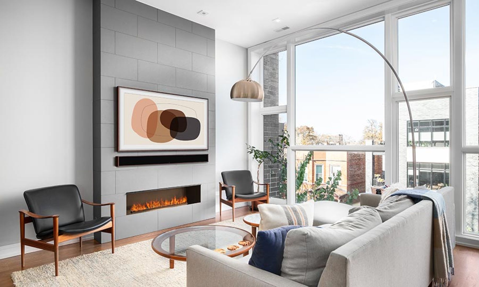 Modern living room with wall-mounted art piece above a sleek fireplace and minimalistic decor.