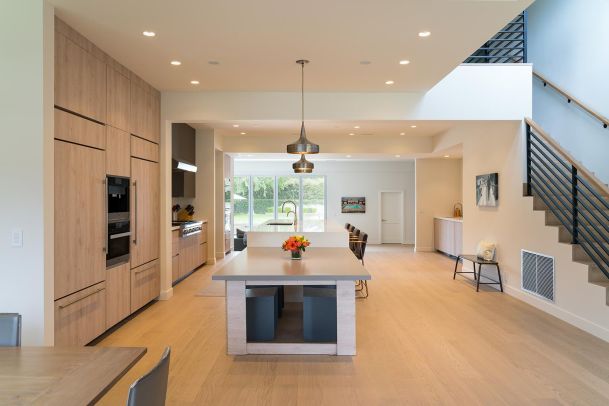 Spacious modern kitchen with wood cabinetry, pendant lighting, and an island.