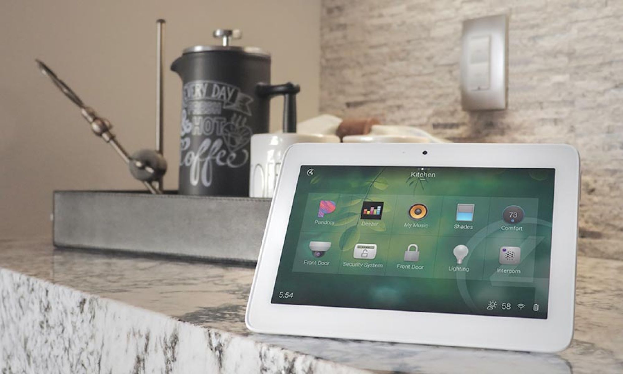 Tablet device displaying home automation controls on a kitchen counter.
